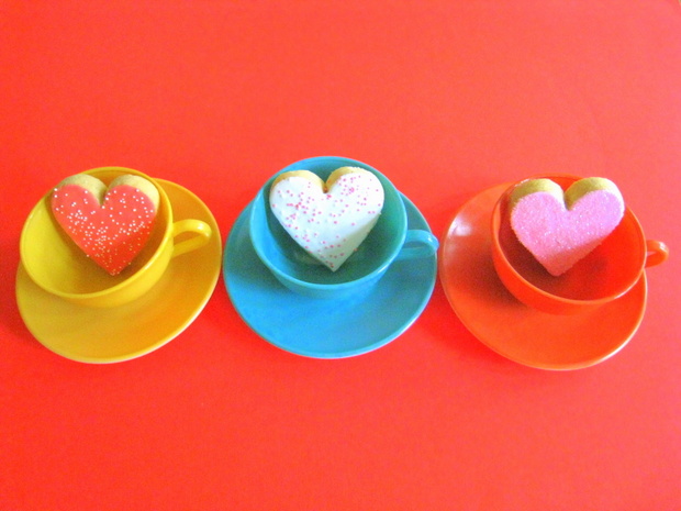 Frosted heart cookies in colorful teacups