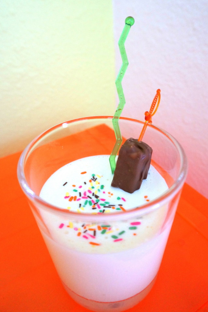 Vanilla milkshake with sprinkles and a Snickers bar garnish